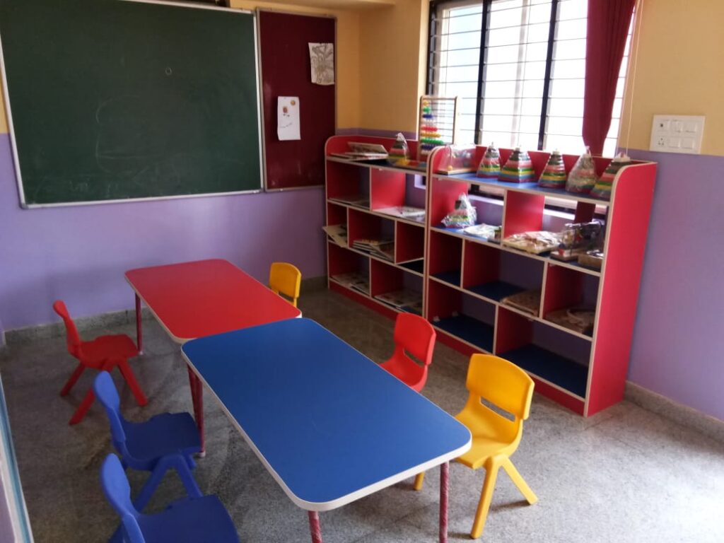 Neat preschool classroom with colorful tables, chairs and learning materials at SSCT Bright Kidz